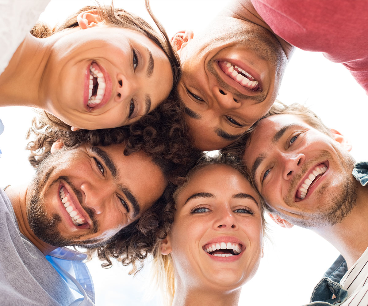 A group of six young adults smiling at the camera, with three males and three females, all appearing happy and enjoying each other s company.